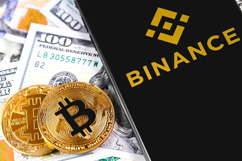 Aplicación de Binance junto a monedas de bitcoin