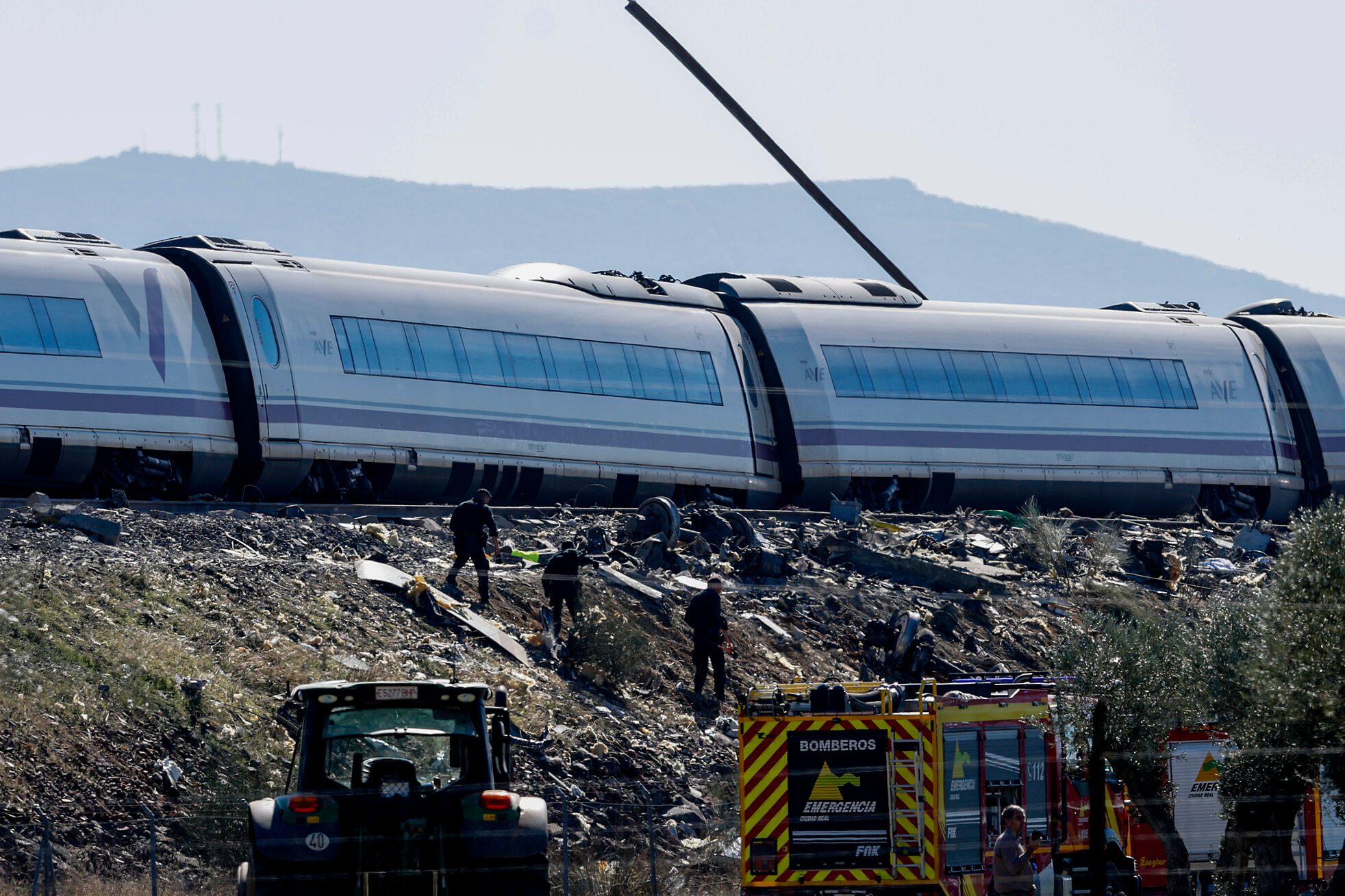 Servicios de emergencia y miembros de la Guardia Civil trabajan en el lugar del accidente de dos trenes de alta velocidad, uno de Renfe y otro de Iryo, que colisionaron ayer.